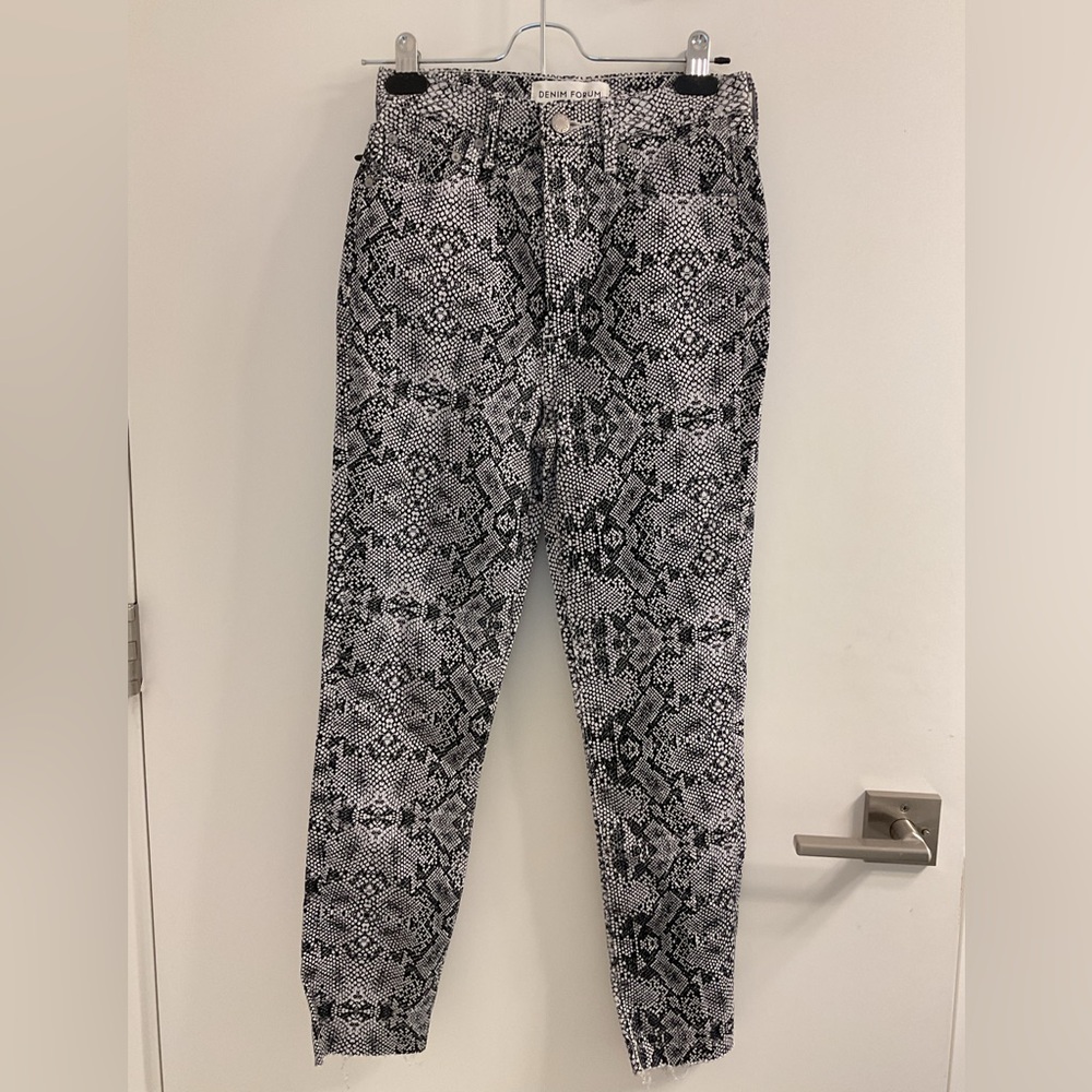 Denim Forum Monochromatic Snake Print denim with raw edges .